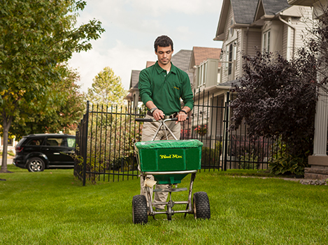 Technicien Weed Man appliquant un fertilisant